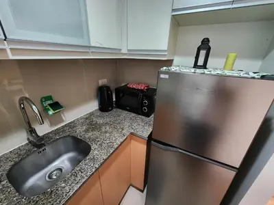 a kitchen with a sink and a stainless steel refrigerator at 81 Newport C5 10i Balcony & Pool across NAIA T3 in Manila