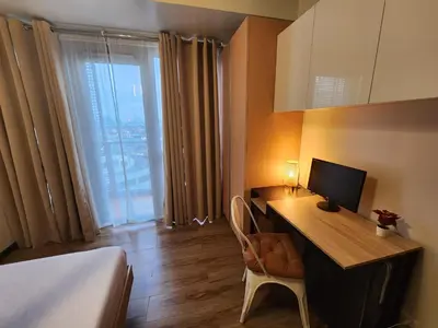 a hotel room with a desk with a computer on it at 81 Newport C5 10i Balcony & Pool across NAIA T3 in Manila
