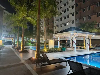 a hotel swimming pool with palm trees and a hotel at Happy Stays A - 300mbps - 65