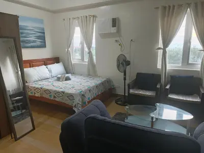 a living room with a bed and a couch at Happy Stays A - 300mbps - 65