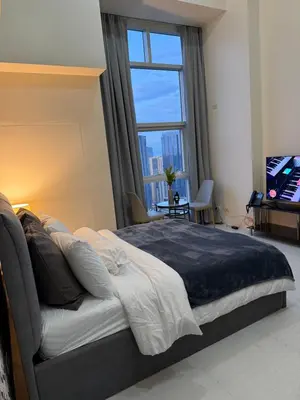 a bedroom with a large bed with a large window at Studio penthouse 1 in Manila