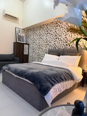 a bedroom with a large bed with a wall at Studio penthouse 1 in Manila