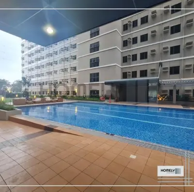 a swimming pool in front of a large building at Homely - SMDC Green 2 Residences, Dasmarinas City in Pasong Bayog