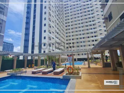 a person standing in front of a large building at Homely - SMDC Green 2 Residences, Dasmarinas City in Pasong Bayog