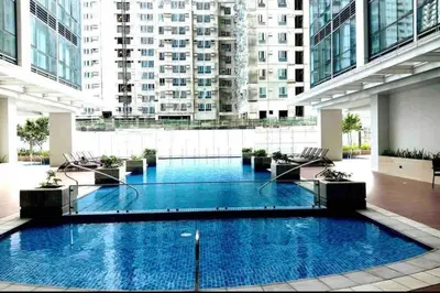 a large swimming pool in a building with tall buildings at One Uptown Residence 1Br 2Bed Affordable for 4,Uptown Mall Linked in Manila
