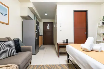 a living room with a couch and a table at One Uptown Residence 1Br 2Bed Affordable for 4,Uptown Mall Linked in Manila