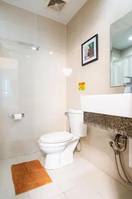 a bathroom with a toilet and a sink at One Uptown Residence 1Br 2Bed Affordable for 4,Uptown Mall Linked in Manila