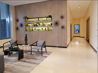 a lobby with two chairs and a shelf with vases at One Uptown Residence 1Br 2Bed Affordable for 4,Uptown Mall Linked in Manila