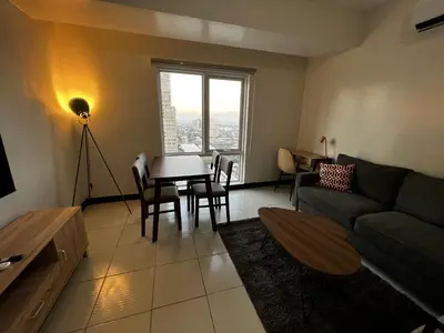 a living room with a couch and a table at AMAZING VIEWS ACROSS SHANGRILA MALL and NEAR MEGAMALL GREENFIELD DISTRICT in Manila