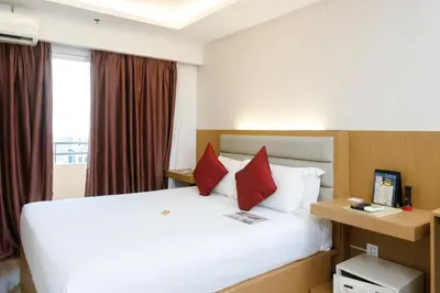 a hotel room with a large bed with red pillows at Regency Grand Suites in Manila