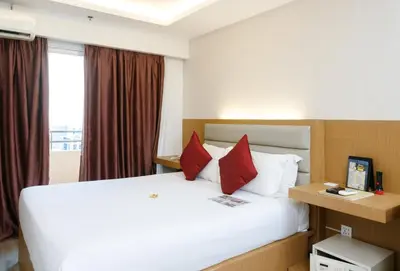 a hotel room with a large bed with red pillows at Regency Grand Suites in Manila