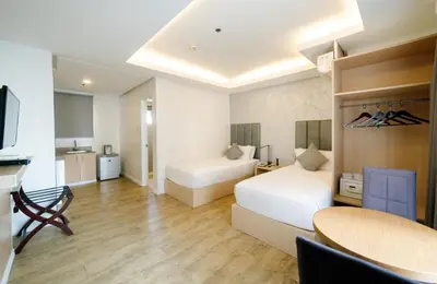 a hotel room with two beds and a table at Regency Grand Suites in Manila