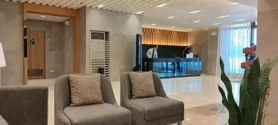 a living room with two chairs and a television at Cozy 1 Bedroom with balcony facing pool near MOA,IKEA near in Manila