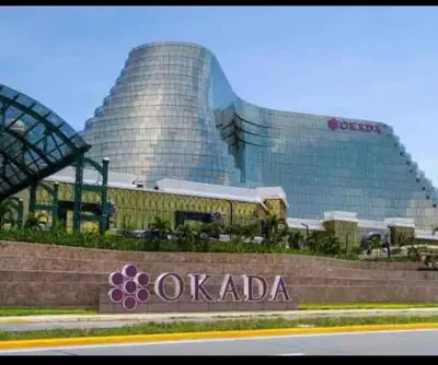 a large building with a sign in front of it at Cozy 1 Bedroom with balcony facing pool near MOA,IKEA near in Manila