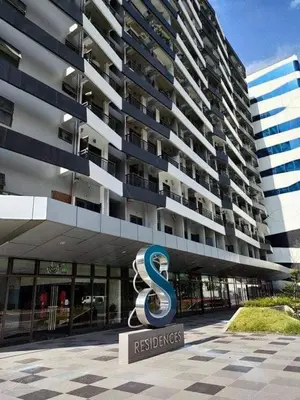 a building with a s sign in front of it at Cozy 1 Bedroom with balcony facing pool near MOA,IKEA near in Manila