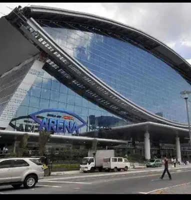 a large building with a sign on the side of it at Cozy 1 Bedroom with balcony facing pool near MOA,IKEA near in Manila