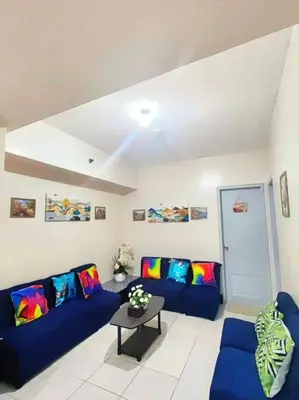 a living room with two blue couches and a table at Spacious 3BR Condo at Little Baguio Terraces San Juan City in Manila