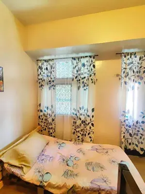 a bedroom with a bed and two windows with curtains at Spacious 3BR Condo at Little Baguio Terraces San Juan City in Manila