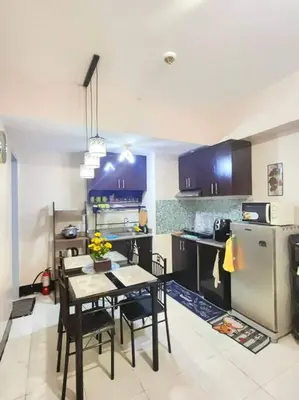 a kitchen with a table and chairs and a refrigerator at Spacious 3BR Condo at Little Baguio Terraces San Juan City in Manila
