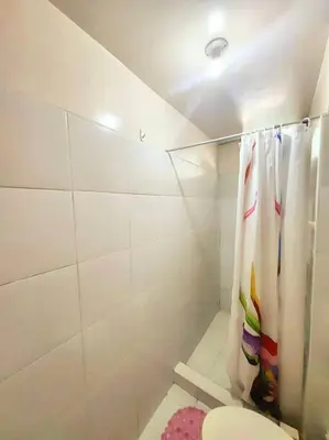 a bathroom with a shower curtain and a toilet at Spacious 3BR Condo at Little Baguio Terraces San Juan City in Manila