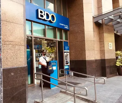 a police officer standing outside of a bdo building at One Bedroom with Netflix at Legaspi Village Makati in Manila
