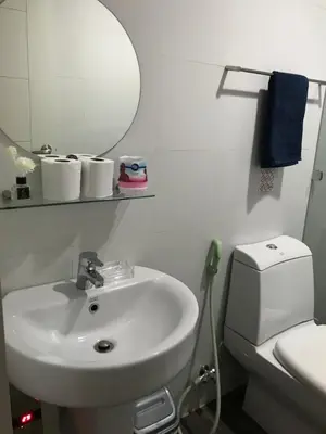 a bathroom with a sink and a toilet and a mirror at One Bedroom with Netflix at Legaspi Village Makati in Manila
