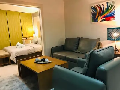a living room with a couch and a bed at One Bedroom with Netflix at Legaspi Village Makati in Manila