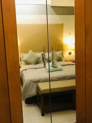 a reflection of a bedroom with two beds and a mirror at One Bedroom with Netflix at Legaspi Village Makati in Manila