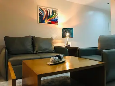 a living room with a couch and a coffee table at One Bedroom with Netflix at Legaspi Village Makati in Manila