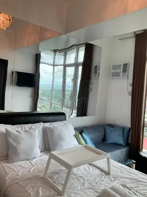 a bedroom with a bed with a table on it at Clazzy Home At San Lorenzo in Manila