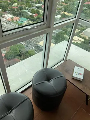 a room with two chairs and a table and a window at Clazzy Home At San Lorenzo in Manila