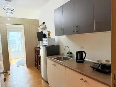 a kitchen with a sink and a refrigerator at Sunshine at Grace nr BGC in Manila