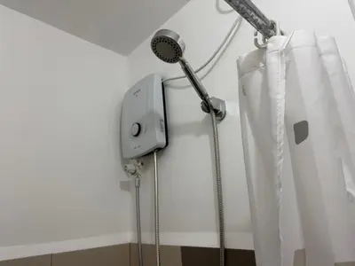 a shower in a bathroom with a shower curtain at Sunshine at Grace nr BGC in Manila