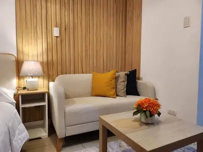a living room with a couch and a table at 331D Near MOA and Airport Pool View Fast WiFi Balcony in Manila