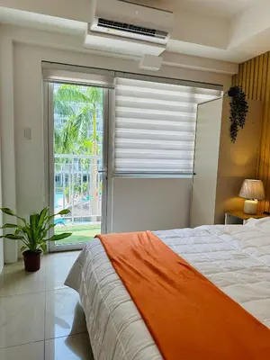 a bedroom with a bed and a large window at 331D Near MOA and Airport Pool View Fast WiFi Balcony in Manila