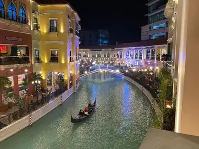 a canal in a city at night with people in a gondola at nJoy! CHIC & Luxury at Venice Grand Canal in Manila
