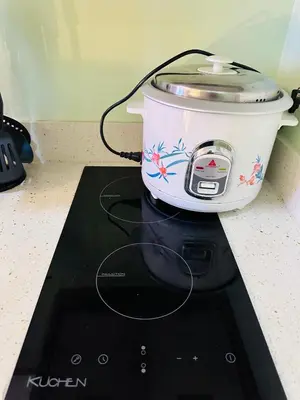 a slow cooker sitting on top of a stove at 5th One Bedroom Condo in Grace Residences Taguig in Manila