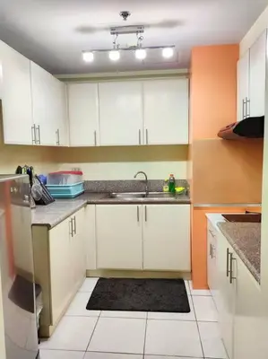 a kitchen with white cabinets and a sink at Lovely Modern 2BR Condo in Aurora Gardens San Juan City in Manila