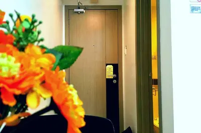 a room with a door and a vase of flowers at 1BR Solemare Aseana MOA Okada Ayala Bay Mall COD Paranaque w/WIFI in Manila