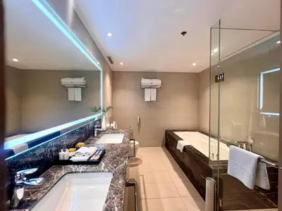 a bathroom with two sinks and a tub and a shower at Seda Manila Bay near Ayala Malls in Manila