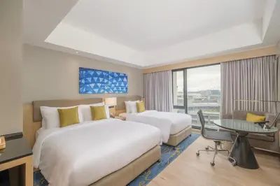 a hotel room with two beds and a desk at Seda Manila Bay near Ayala Malls in Manila