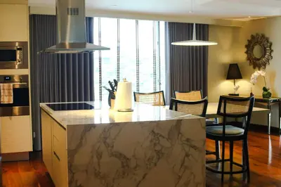 a kitchen and dining room with a marble counter top at Poblacion Penthouse Suite with Private Roofdeck in Manila