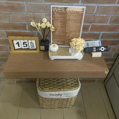 a wooden table with a clock and flowers on it at Lovely Unit with free wi-fi & netflix I across Naia T3 airport in Manila