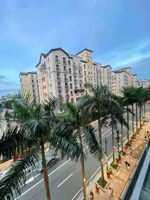a street with palm trees in front of a large building at Lovely Unit with free wi-fi & netflix I across Naia T3 airport in Manila