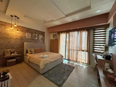 a bedroom with a bed and a brick wall at Lovely Unit with free wi-fi & netflix I across Naia T3 airport in Manila