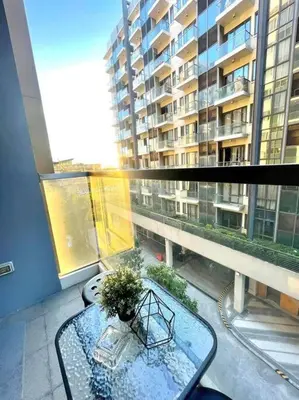 a balcony with a glass table and a large building at Lovely Unit with free wi-fi & netflix I across Naia T3 airport in Manila