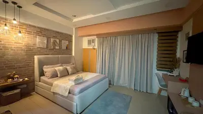 a bedroom with a bed and a brick wall at Lovely Unit with free wi-fi & netflix I across Naia T3 airport in Manila