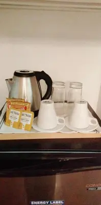 a tea pot and two cups on a counter at L and D Homestay in Manila