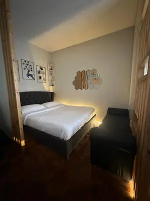 a bedroom with a bed and a ottoman at L and D Homestay in Manila