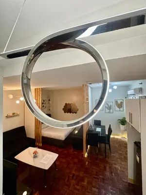 a large circular mirror hanging from the ceiling of a room at L and D Homestay in Manila